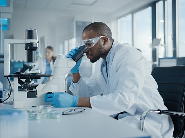 Scientific researcher looking through a microscope